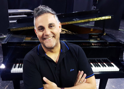 Joseph-Aridan-smiling-near-piano-at-studio